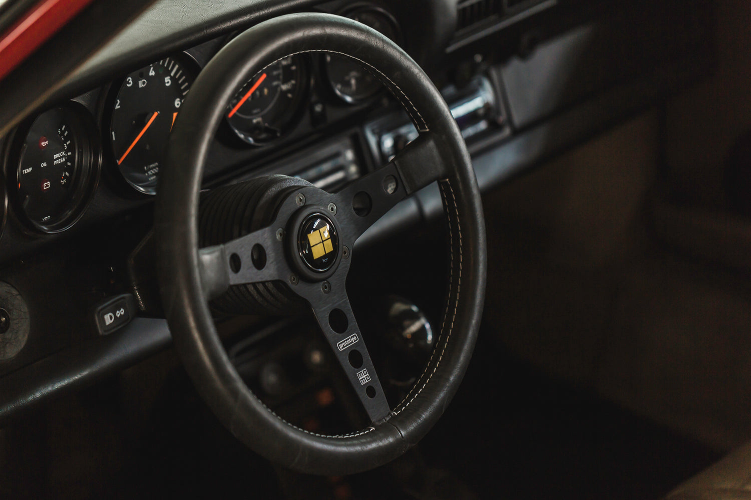 Detailed interior view of a Porsche 911 – steering wheel, dashboard, and classic sports car design.