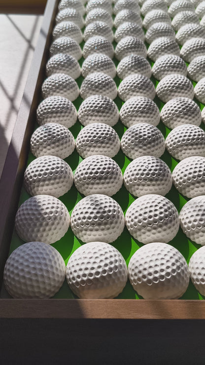 Golfball - 3D Kunst; Weißes Golfball Bild mit rotem Akzent auf grünem Hintergrund; 53x53 cm