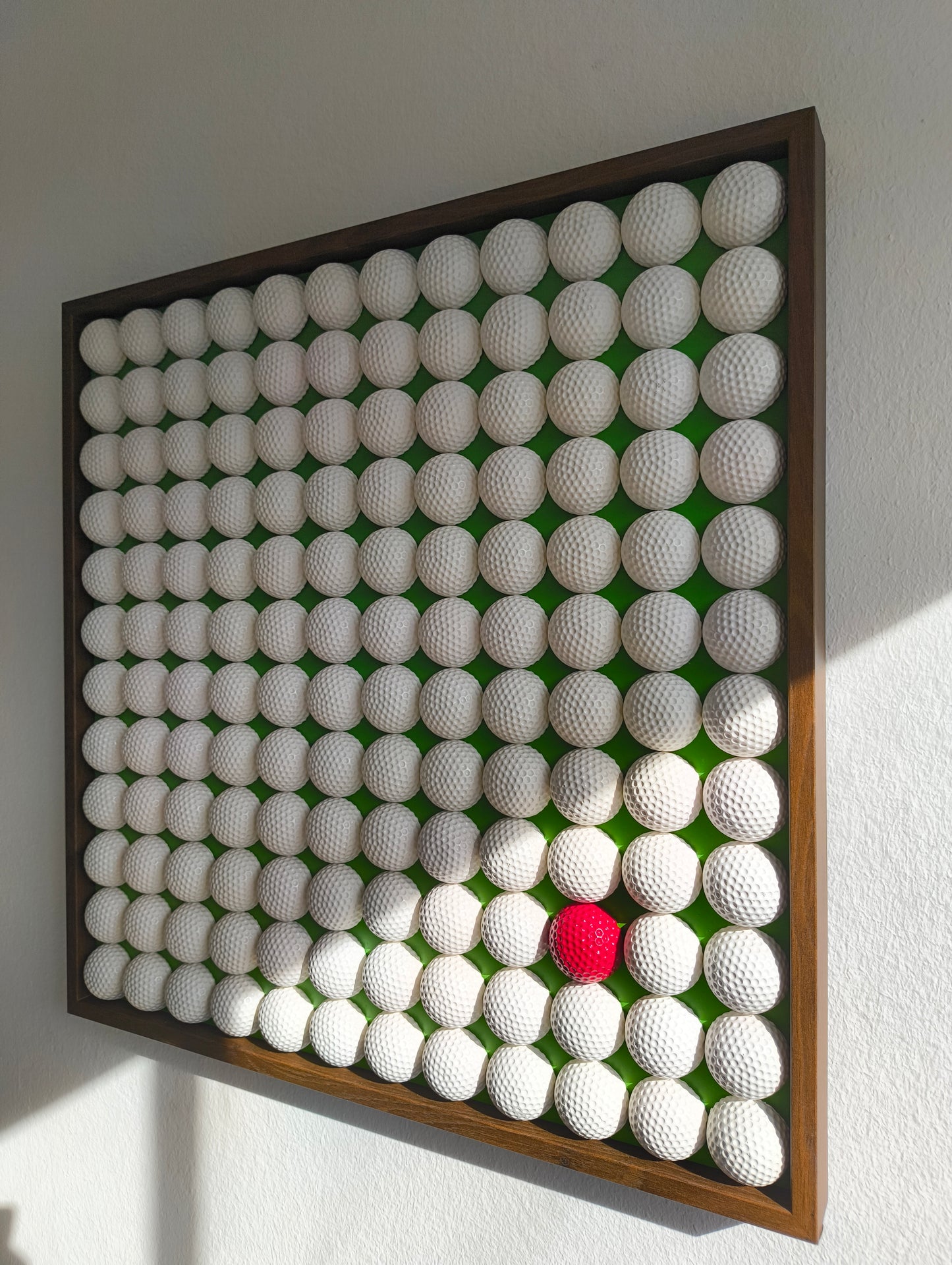 Golfball - 3D Kunst; Weißes Golfball Bild mit rotem Akzent auf grünem Hintergrund; 53x53 cm
