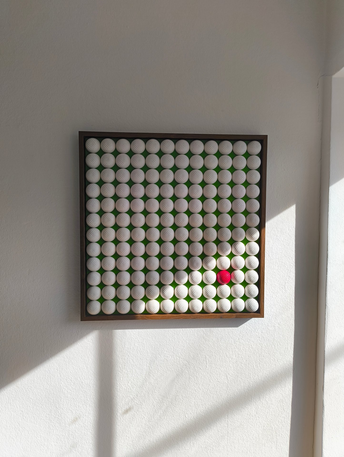 Golfball - 3D Kunst; Weißes Golfball Bild mit rotem Akzent auf grünem Hintergrund; 53x53 cm