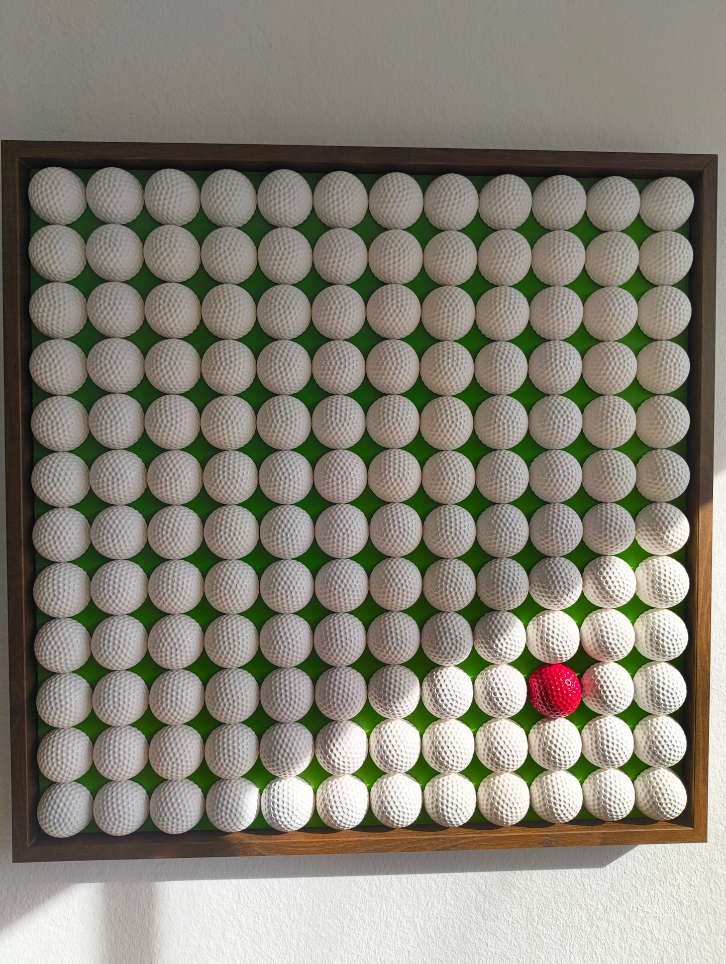 Golfball - 3D Kunst; Weißes Golfball Bild mit rotem Akzent auf grünem Hintergrund; 53x53 cm