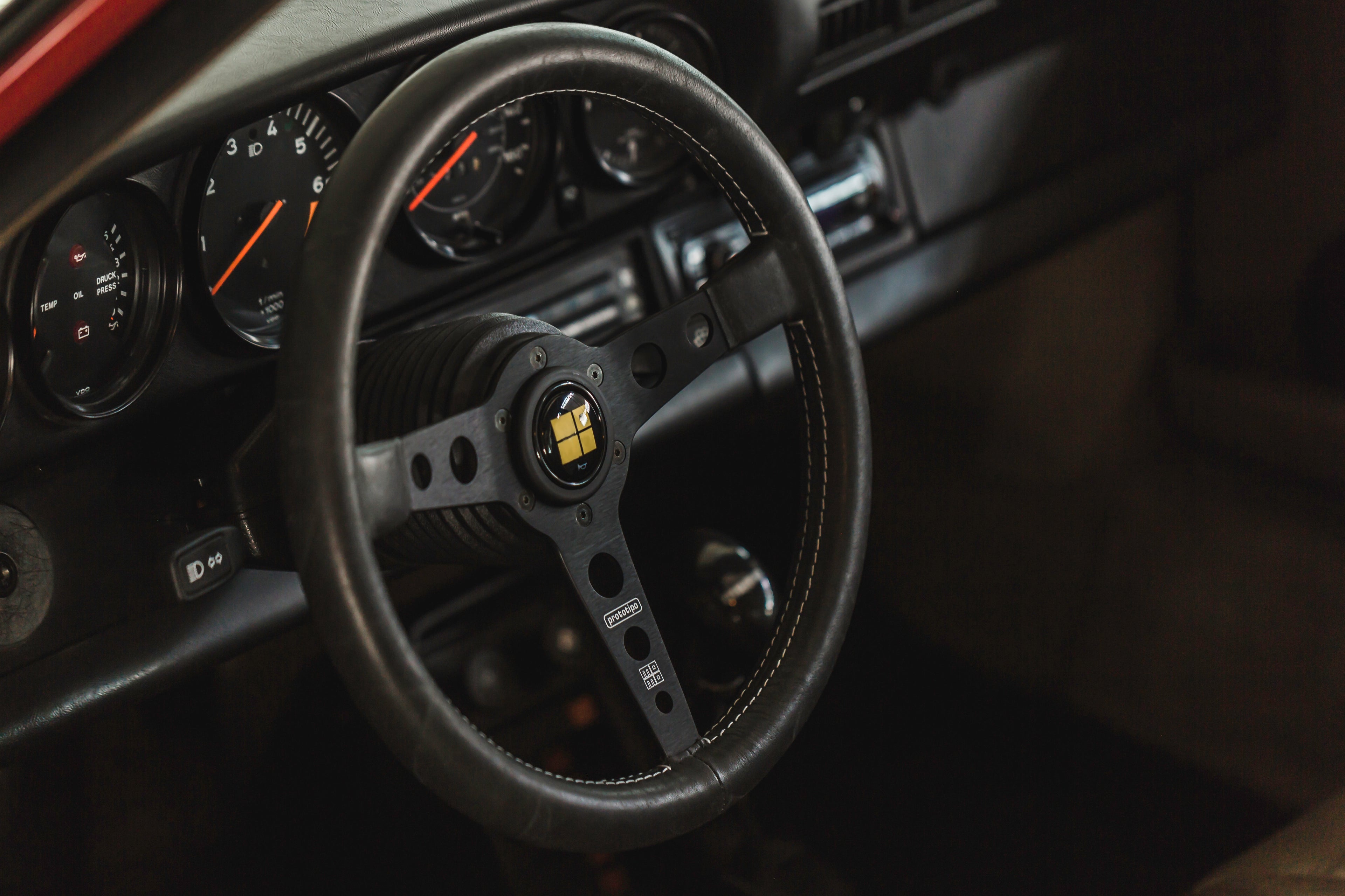 Detailed interior view of a Porsche 911 – steering wheel, dashboard, and classic sports car design.